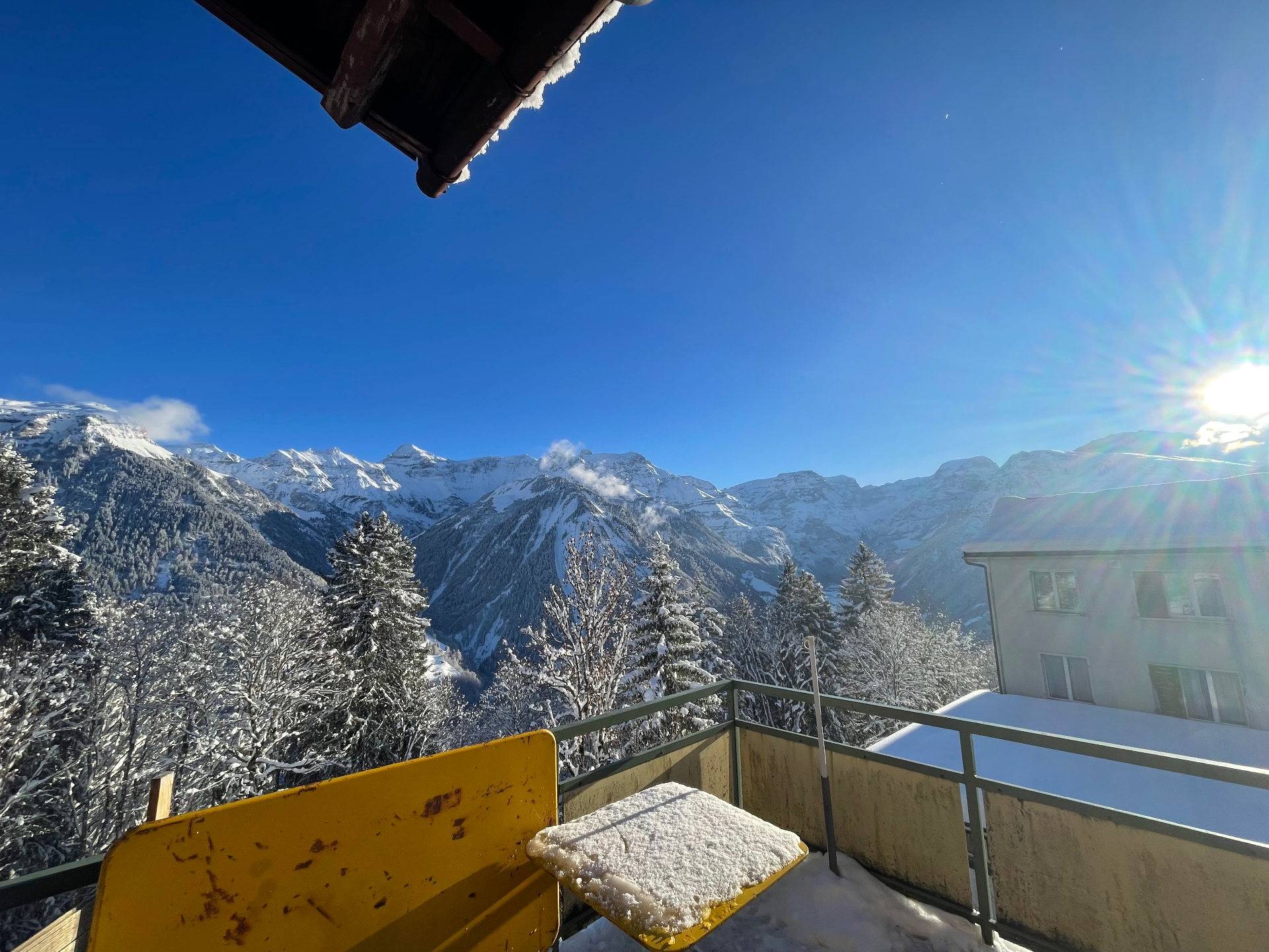 Balkon mit Panoramablick auf die verschneiten Glarner Alpen