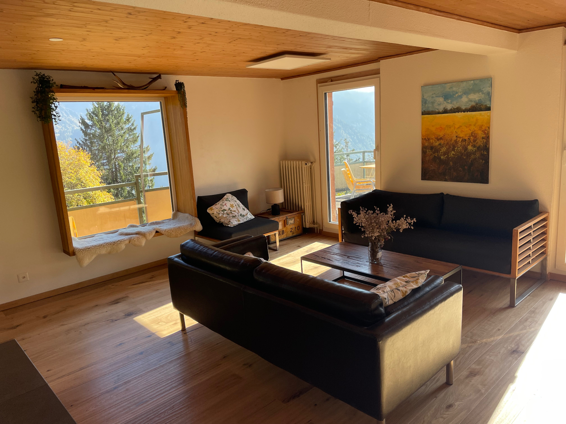 Helles Wohnzimmer mit Panoramafenster und Blick auf die Berge