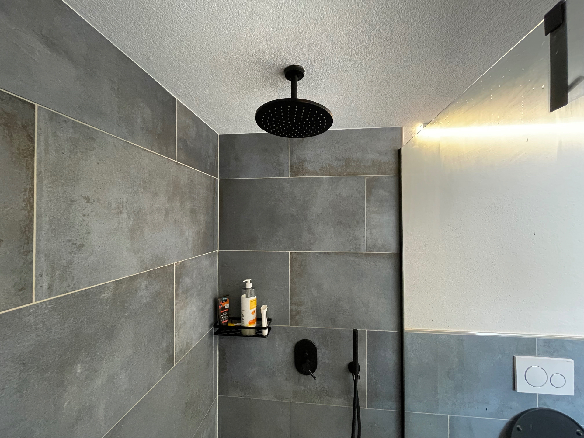 Modernes Badezimmer mit grossem Regenduschkopf und Schiefer-Optik